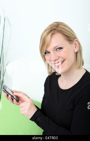 Smiling woman sending a text message Stock Photo