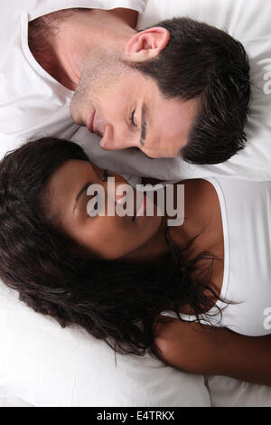 Man and woman laid in bed Stock Photo