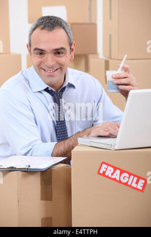 man amid cardboard boxes Stock Photo