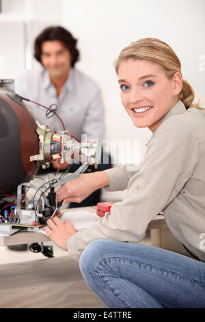 Woman repairing television Stock Photo