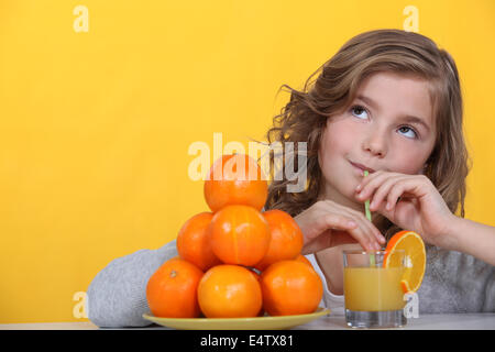 Girl drinking orange juice Stock Photo