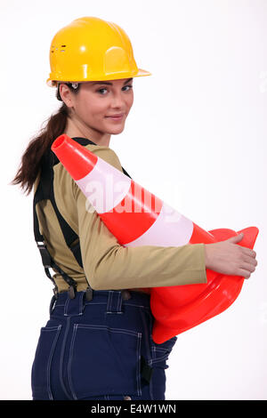 Female builder holding traffic cone Stock Photo