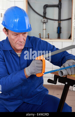 Plumber cutting length of plastic pipe Stock Photo