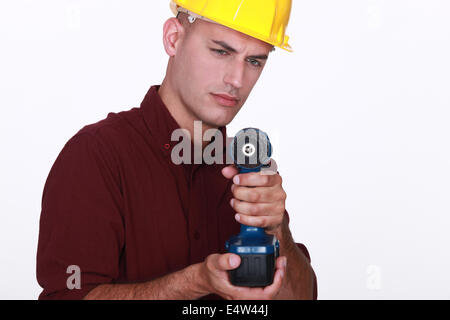 Tradesman aiming his power tool Stock Photo