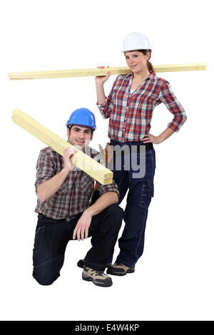 Labourers carrying wooden planks Stock Photo