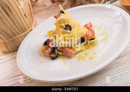 tagliatelle with bacon and blacken to olive ones Stock Photo