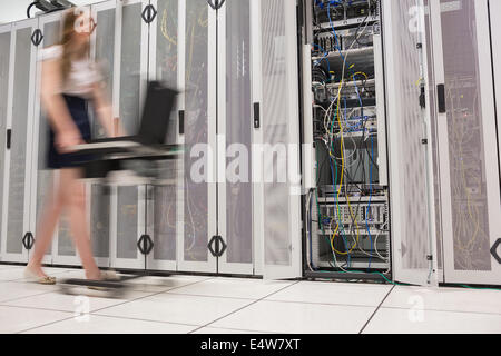 Woman pushing computer through data center Stock Photo