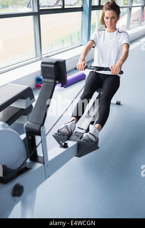 Energetic woman training on row machine Stock Photo - Alamy