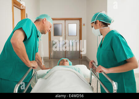 Surgeons leaning on a medical bed Stock Photo