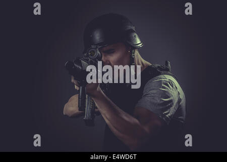 Security  sport player wearing protective helmet aiming pistol ,black armor and machine gun Stock Photo