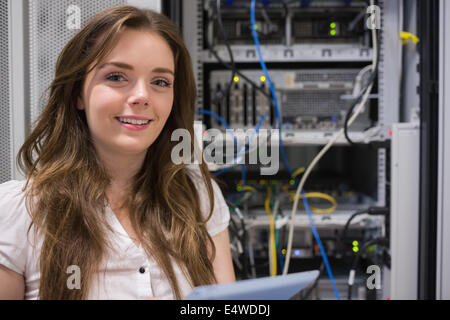 Smiling woman standing in front of servers Stock Photo