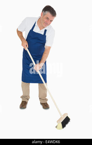 Happy man sweeping floor Stock Photo