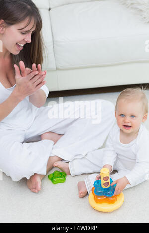 Funny baby sitting on sofa and Christmas tree on background Stock Photo