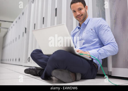 Man working on laptop connected to server Stock Photo