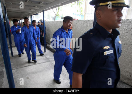 Manila, Philippines. 17th July, 2014. A member of the Philippine Coast Guard (PCG) leads the four rescued Filipino fishermen inside the PCG Headquarters in Manila, the Philippines, on July 17, 2014. The crew of Chinese vessel MV Pacific Pioneer, which came from Hong Kong of China, rescued the four Filipino fishermen who were in the sea for two days after their vessel was submerged in the strong wind brought by typhoon Rammasun. © Rouelle Umali/Xinhua/Alamy Live News Stock Photo