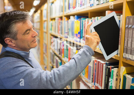 Man taking a tablet pc from the shelves Stock Photo