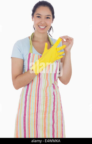 Woman in apron taking off rubber gloves Stock Photo