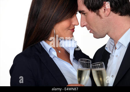 Flirtatious business couple drinking champagne Stock Photo