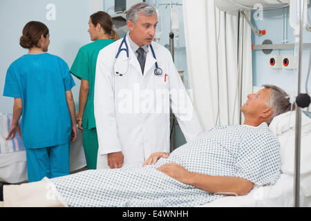 Patient  lying in bed talking to  doctor Stock Photo