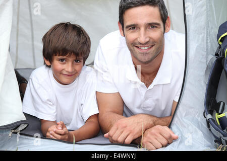 Father and son camping in a tent Stock Photo