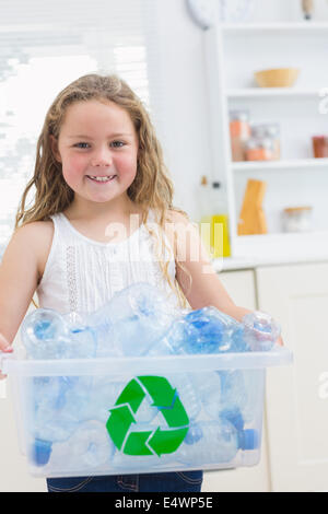 Smiling girl carrying box of the bottles Stock Photo