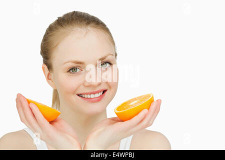 Smiling woman holding oranges Stock Photo