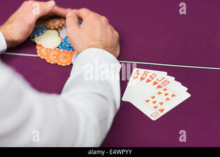 Man winning at poker with royal flush Stock Photo