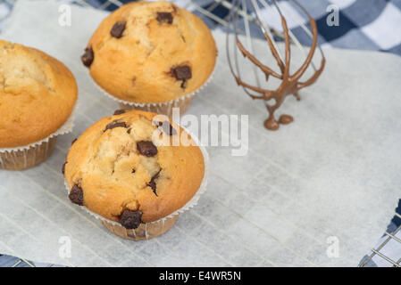 Home made chocolate chip muffins with melting chocolate on whisk Stock Photo