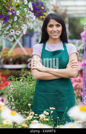 Joyful female gardener looking at camera and smiling while holding ...