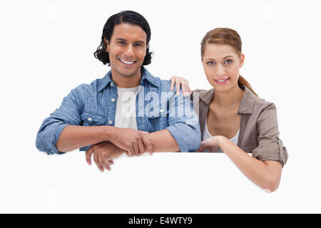 Couple leaning on blank wall Stock Photo