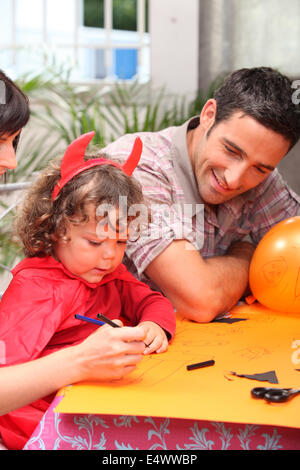 little girl dressed as a devil drawing Stock Photo