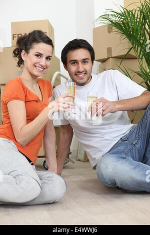 Couple sat in new apartment Stock Photo