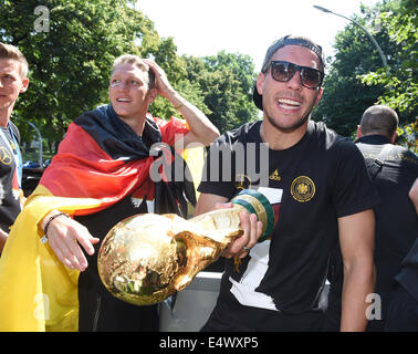 HANDOUT - Germany's Lukas Podolski celebrates on the truck to the World Cup party at the Brandenburg Gate after team Germany arrived back in Germany in front of in Berlin, Germany, 15 July 2014. The German team won the Brazil 2014 FIFA Soccer World Cup final against Argentina by 1-0 on 13 July 2014, winning the world cup title for the fourth time after 1954, 1974 and 1990. Photo: Markus Gilliar/GES/DFB/dpa (ATTENTION: Editorial use only and mandatory credit 'Photo: Markus Gilliar/GES/DFB/dpa') Stock Photo