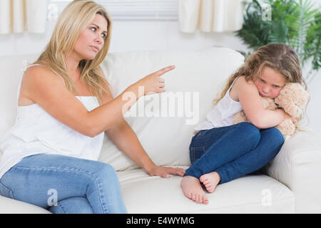 Mother scolding daughter clutching teddy bear Stock Photo