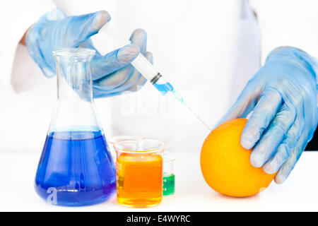 Chemist injecting product in an orange Stock Photo