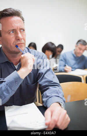 Mature student thinking in class Stock Photo