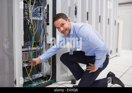Technician plugging cable into server Stock Photo