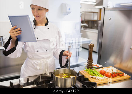 Female chef using tablet pc while cooking Stock Photo