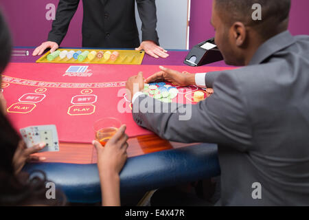 Man grabbing chips at poker table Stock Photo