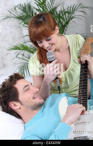 Young couple with a guitar and a microphone Stock Photo