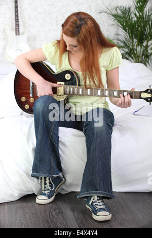 Girl playing electric guitar Stock Photo