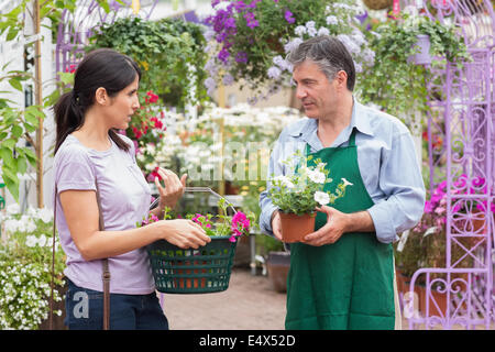 Customer talking to garden center worker Stock Photo