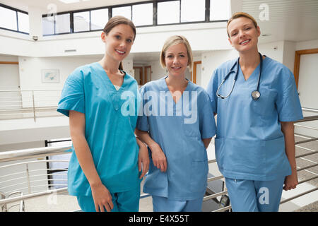 Three nurses leaning against railing Stock Photo