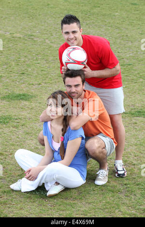 Friends taking a break from playing football Stock Photo