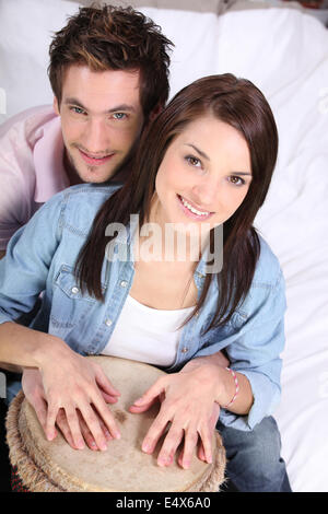 Couple playing a bongo drum Stock Photo