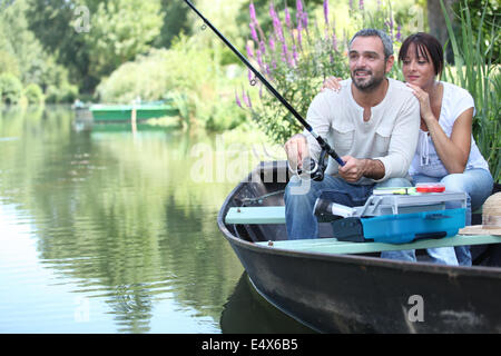 Couple fishing in a small boat on a river Stock Photo