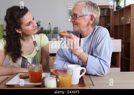 Grandmother and granddaughter having breakfast Stock Photo