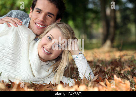 Young couple lying on the grass together Stock Photo