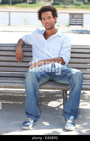 Young man sitting on bench Stock Photo