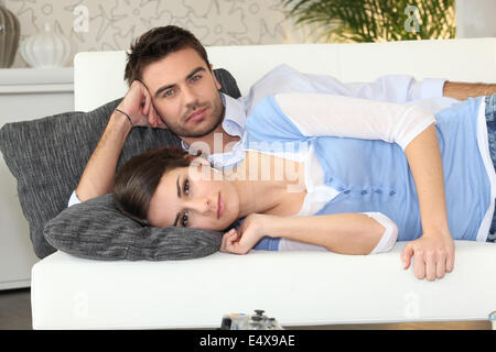 Couple lying on a couch together Stock Photo